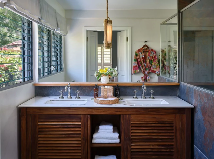 Elegant bathroom with natural stone finishes in a beachfront cottage at East Winds Resort, St. Lucia, all inclusive