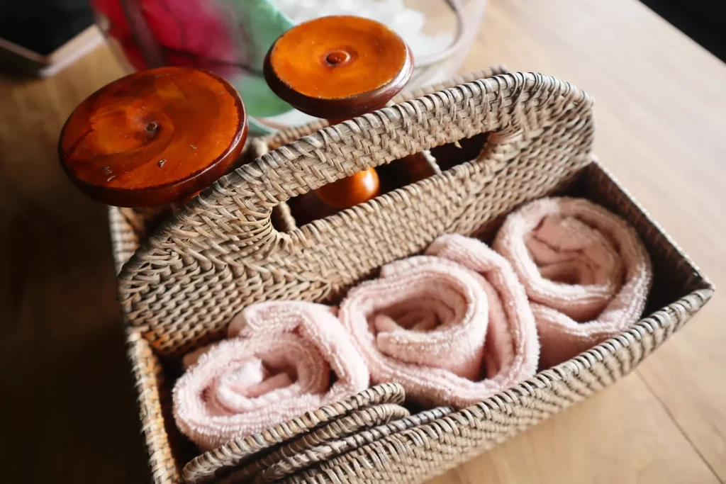 A beautifully arranged spa basket with soft rolled towels, wooden massage oils, and luxurious essentials, offering a serene and relaxing spa experience at East Winds, St. Lucia