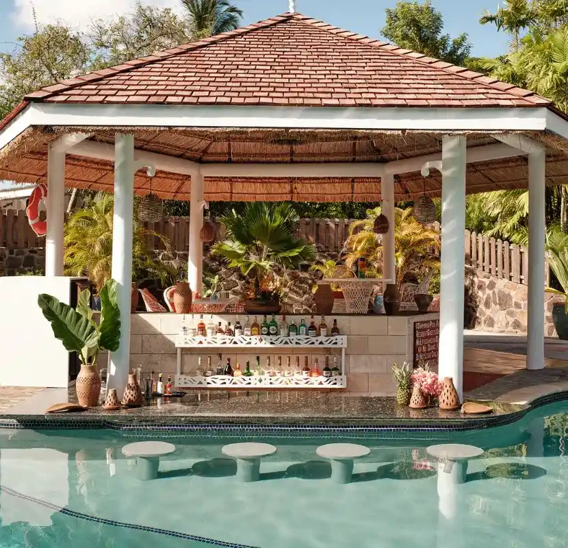 Swim-up bar under a thatched-roof gazebo with lush greenery | East Winds Resort Saint Lucia