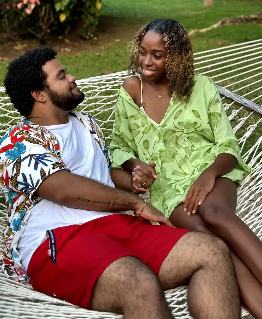 Couple enjoying a relaxed moment together on a hammock in a lush garden.