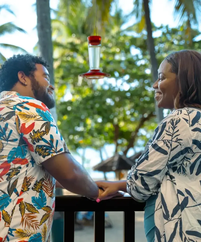 Couple enjoying a moment together by the beach with vibrant tropical scenery.